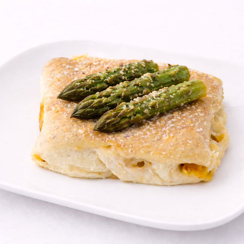 dettaglio di asparagi e besciamella su crespella vegan